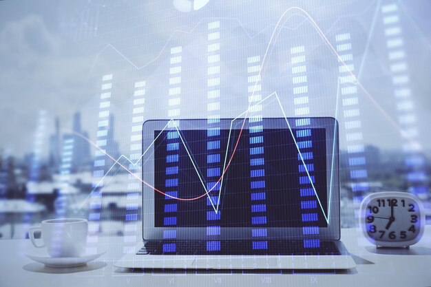 Holograma de gráfico de divisas en la mesa con fondo informático Múltiple exposición Concepto de mercados financieros