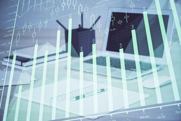Holograma de gráfico de divisas en la mesa con fondo informático Múltiple exposición Concepto de mercados financieros
