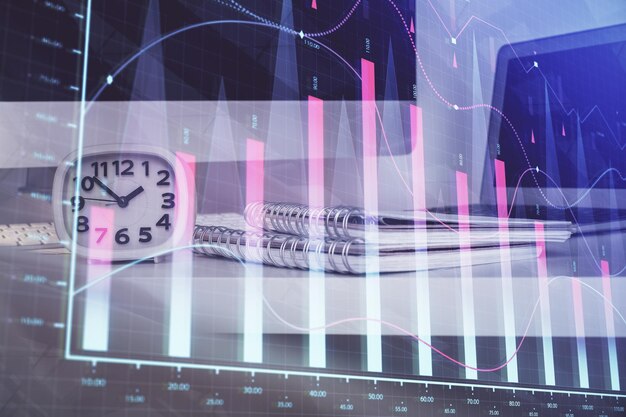 Holograma de gráfico de divisas en la mesa con fondo informático Múltiple exposición Concepto de mercados financieros
