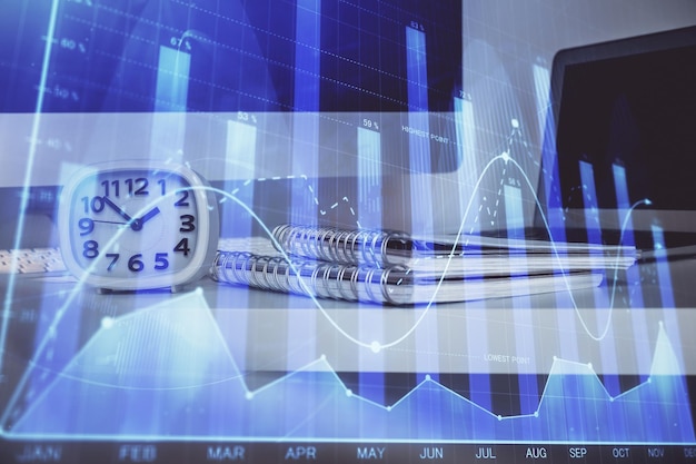 Holograma de gráfico de divisas en la mesa con fondo informático Múltiple exposición Concepto de mercados financieros