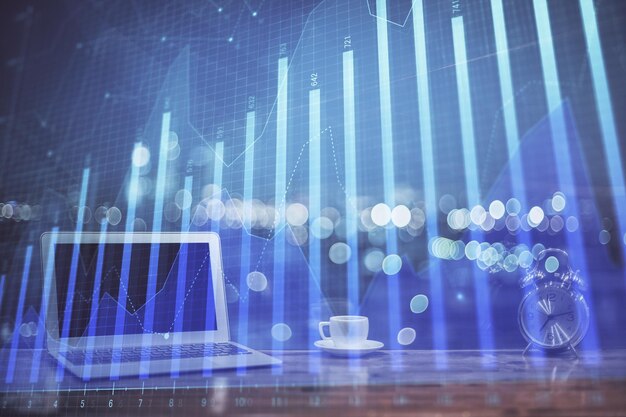 Holograma de gráfico de divisas en la mesa con fondo informático Múltiple exposición Concepto de mercados financieros