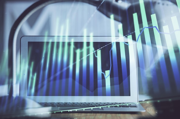 Holograma de gráfico de divisas en la mesa con fondo informático Múltiple exposición Concepto de mercados financieros