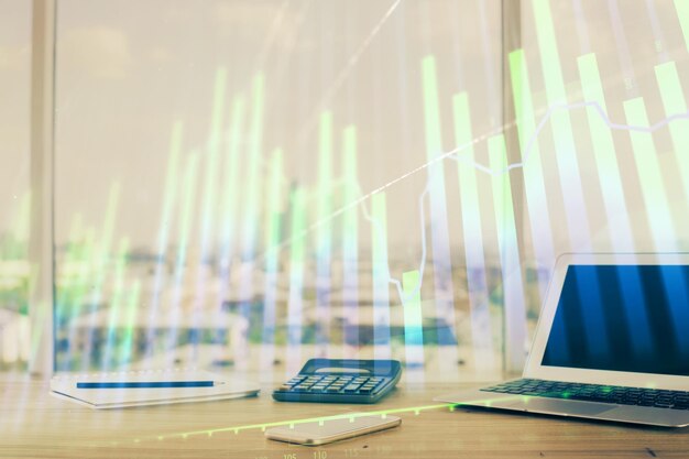 Holograma gráfico de forex en la mesa con fondo de computadora Concepto de exposición múltiple de los mercados financieros