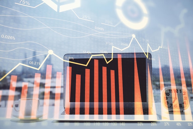 Holograma gráfico de forex en la mesa con fondo de computadora Concepto de exposición múltiple de los mercados financieros