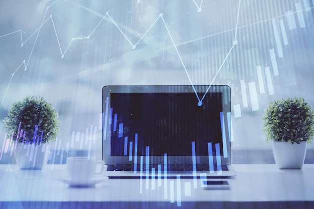Holograma gráfico de Forex en la mesa con fondo de computadora Concepto de exposición múltiple de los mercados financieros