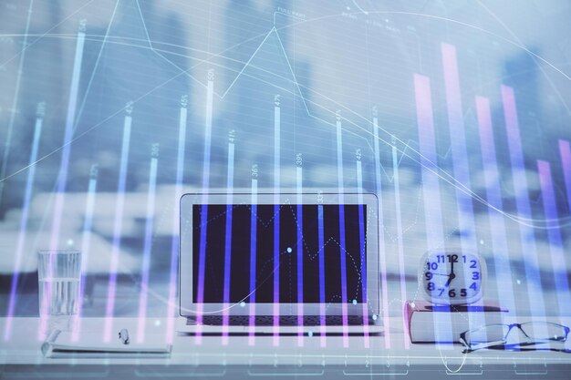 Holograma gráfico de Forex en la mesa con fondo de computadora Concepto de exposición múltiple de los mercados financieros