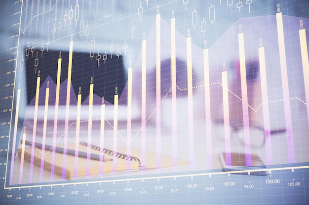 Holograma gráfico de Forex en la mesa con fondo de computadora Concepto de exposición múltiple de los mercados financieros