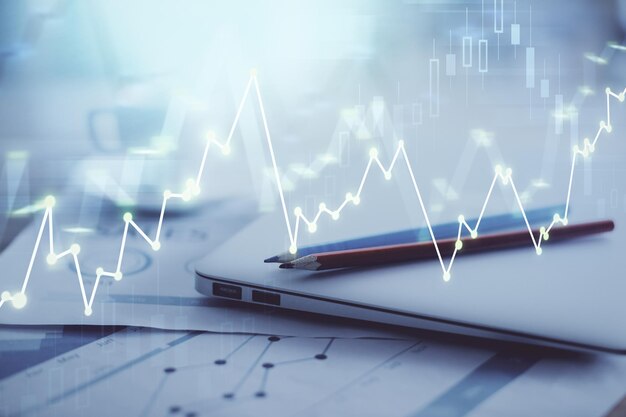 Holograma gráfico de forex en la mesa con fondo de computadora Doble exposición Concepto de mercados financieros