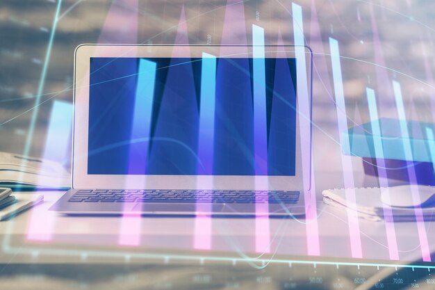Holograma del gráfico del mercado de divisas y computadora personal en el fondo Exposición múltiple Concepto de inversión