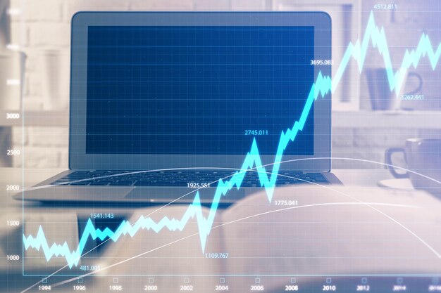 Holograma de gráfico de mercado de divisas y computadora personal en el fondo Exposición múltiple Concepto de inversión