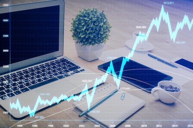Holograma del gráfico del mercado de divisas y computadora personal en el fondo Exposición múltiple Concepto de inversión