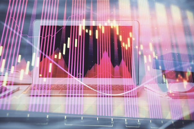 Holograma del gráfico del mercado de divisas y computadora personal en el fondo Exposición múltiple Concepto de inversión