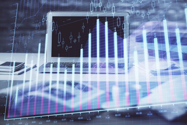 Holograma del gráfico del mercado financiero y computadora personal en el fondo Doble exposición Concepto de divisas