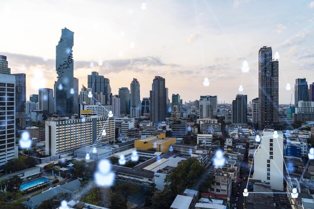 Holograma de íconos de redes sociales sobre el paisaje urbano panorámico al atardecer de Bangkok, Sudeste Asiático El concepto de conexiones de personas y oportunidades profesionales Exposición múltiple