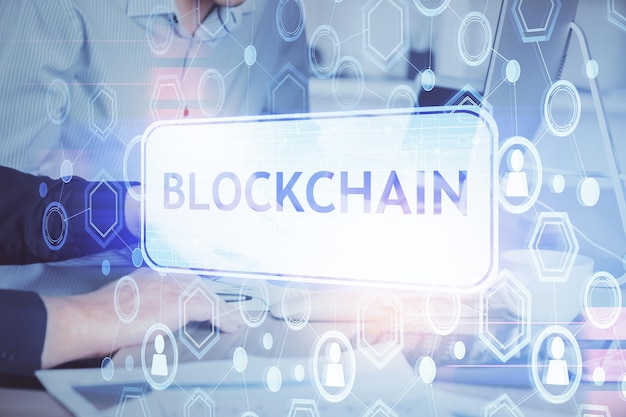 Holograma de tema de moneda criptográfica con un hombre de negocios que trabaja en una computadora en el fondo Concepto de exposición múltiple blockchain