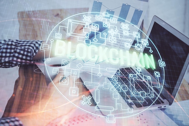 Holograma de tema de moneda criptográfica con un hombre de negocios que trabaja en una computadora en segundo plano Concepto de cadena de bloques Doble exposición
