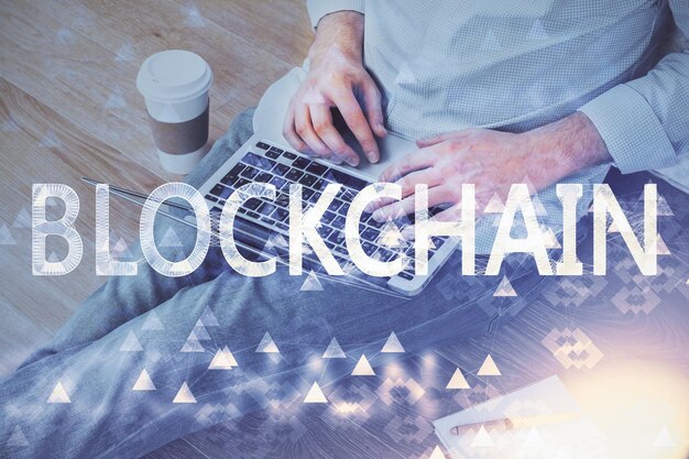 Holograma de tema de moneda criptográfica con un hombre de negocios que trabaja en una computadora en segundo plano Concepto de cadena de bloques Doble exposición