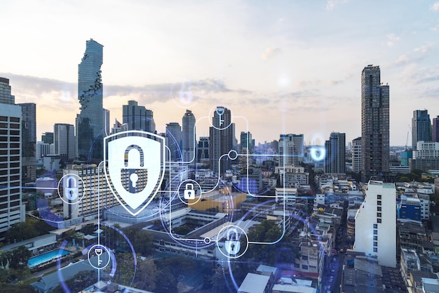 Hologramm des Vorhängeschlosses bei Sonnenuntergang Panorama-Stadtbild von Bangkok Südostasien Das Konzept der Cyber-Sicherheitsintelligenz Mehrfachbelichtung