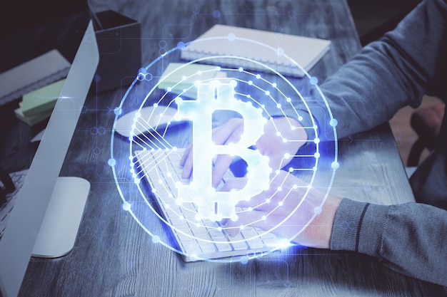 Hologramm zum Thema Kryptowährung mit Geschäftsmann, der am Computer im Hintergrund arbeitet Konzept der Blockchain-Mehrfachbelichtung