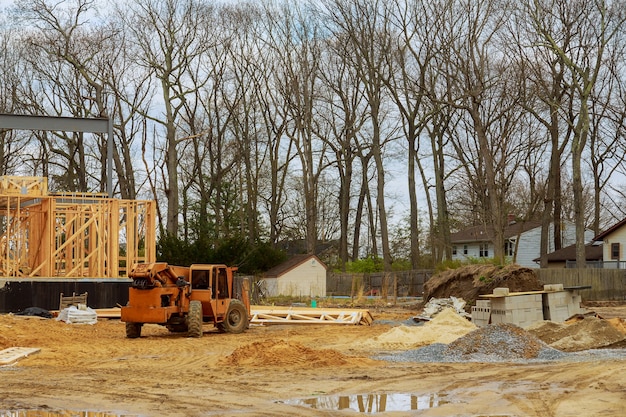 Holz Gebäuderahmen auf neuem Wohnbauhaus, das einen Boom-LKW-Gabelstapler im neuen Haus einrahmt