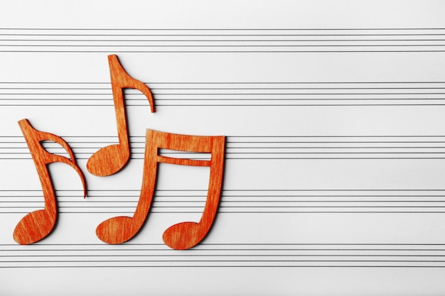 Holz-Musiknoten auf Musikblatt-Hintergrund