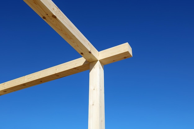 Holzbalken der Baustruktur auf dem Hintergrund des blauen Himmels