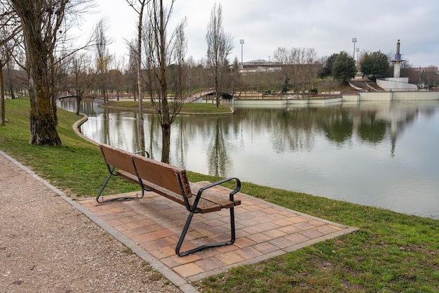 Holzbank zum Sitzen und Ausruhen in einem öffentlichen Park mit Blick auf den kristallklaren See