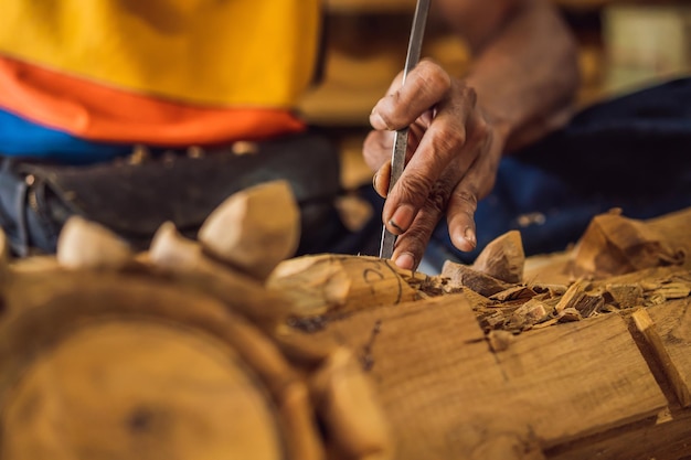 Holzbildhauermeister fertigte mit einem speziellen Messer ein hölzernes Nationalgericht, eine Schöpfkelle mit gemustertem Griff a