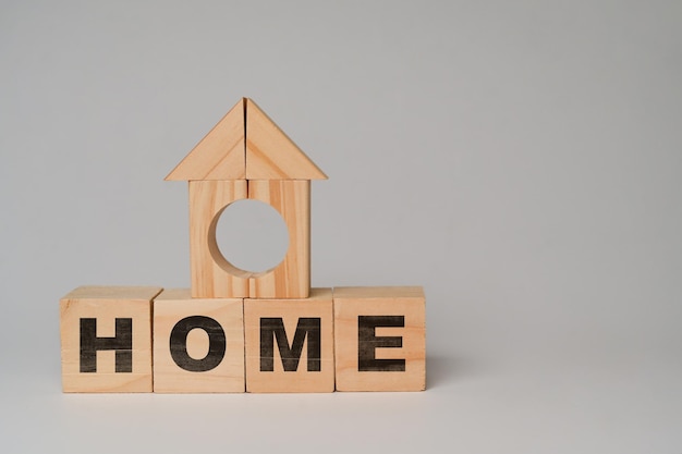 Holzblöcke HOME Wort auf weißem Hintergrund Immobilieninvestitionen Immobilien- und Vermögensverwaltungskonzept