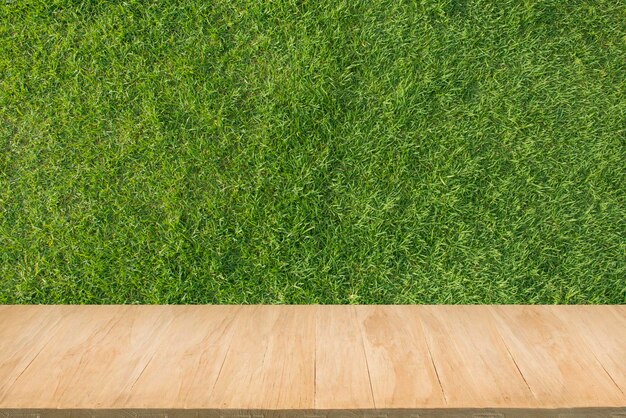 Holzboden mit Hintergrund aus grünem Gras