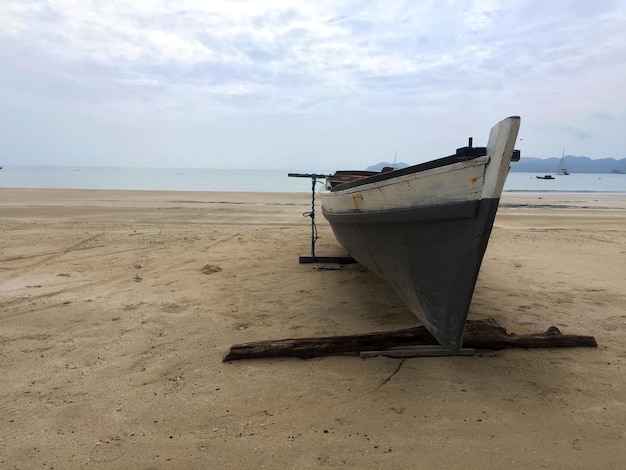 Foto holzboot auf dem weißen sand