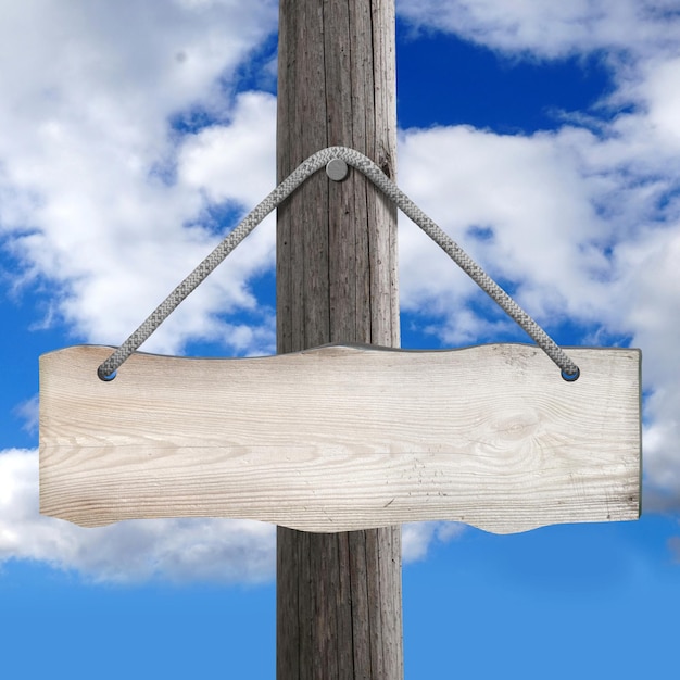 Holzbrett, das am Pfosten an einem Seil mit Himmel im Hintergrund hängt
