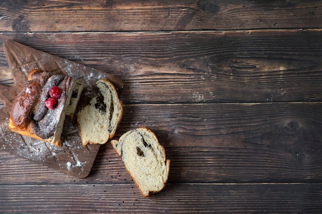 Holzbrett der Torte mit Mohn auf einem Tisch platziert.