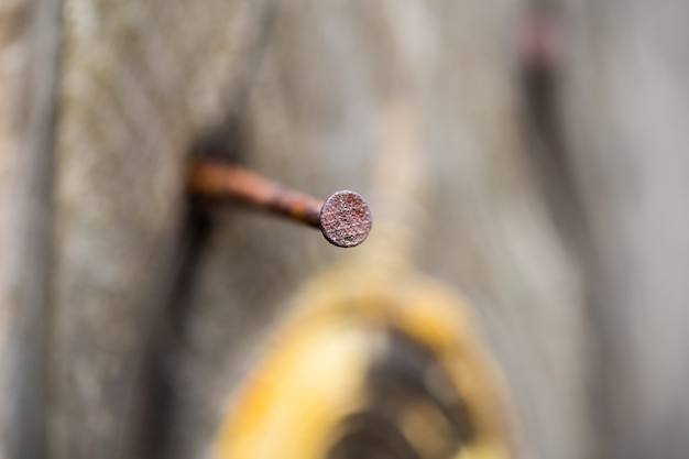 Holzbrett mit einem rostigen Nagel