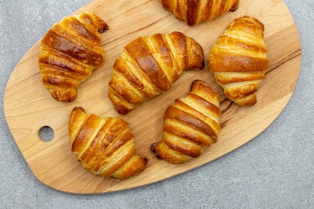 Holzbrett mit frisch gebackenen Croissants