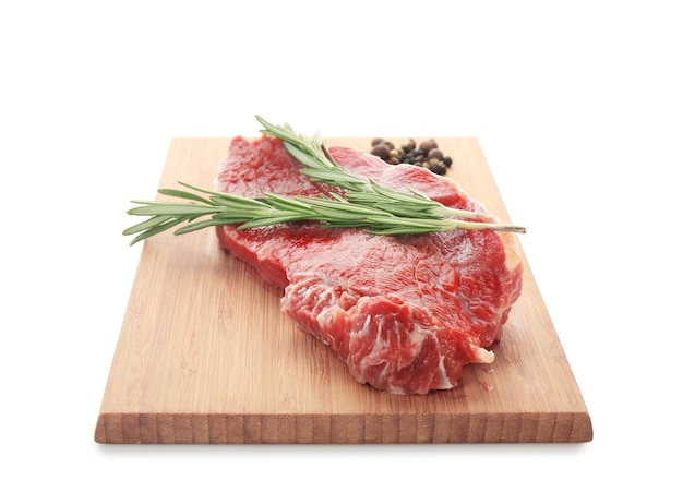 Holzbrett mit frischem rohem Fleisch und Rosmarin auf weißem Hintergrund