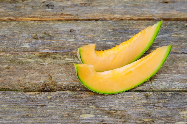 Holzbrett mit leckeren Melonenscheiben auf dem Tisch