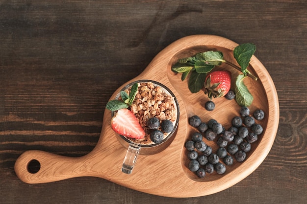 Holzbrett mit Müsli und Beeren