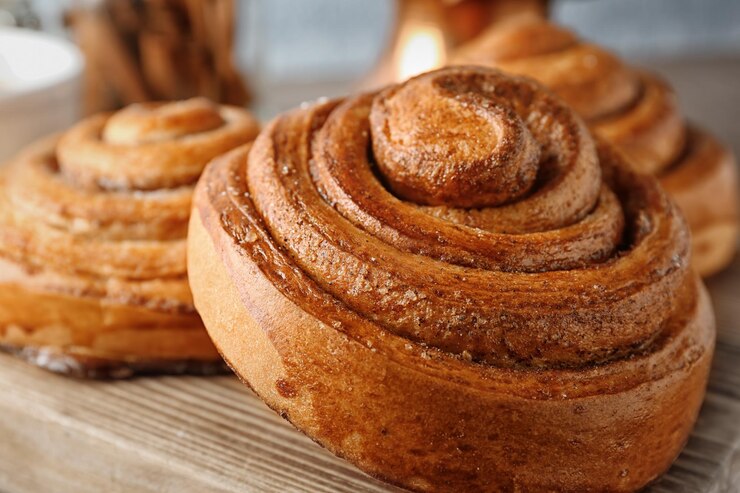 Holzbrett mit süßer Zimtschnecken-Nahaufnahme