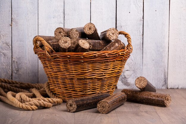 Holzbriketts Biobrennstoffe in einem Korb isoliert auf weißem Hintergrund als natürliche Energiequelle