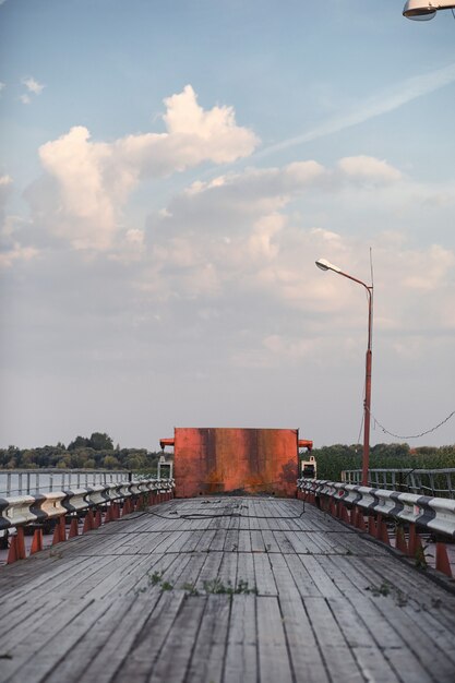 Holzbrücke am Flussufer. Holzstraße mit Säulen. Pantone-Holzbrücke.