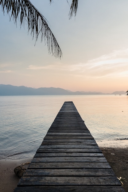 Holzbrücke im Meer bei Sonnenaufgang