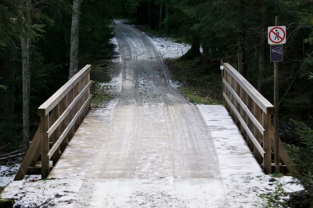 Holzbrücke im Wald. Schneebedeckte Straße