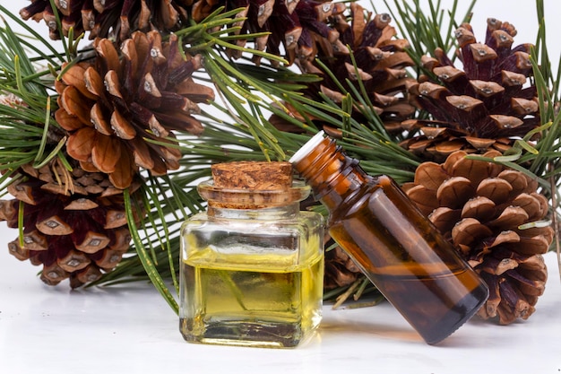 Holzdüfte für die Aromatherapie im Winter. Tannenzapfen und frische grüne Tannenzweige, Flaschen mit ätherischen Ölen