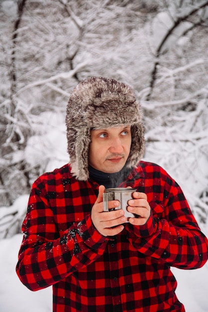 Holzfäller im verschneiten Winterwald Hipster mit Axt Holzfäller Lifestyle gutaussehender Mann, der im Wald arbeitet