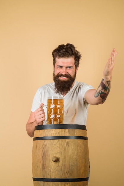 Holzfass und Bierglas oktoberfest glücklicher bärtiger mann mit glas bier wir treffen oktoberfest