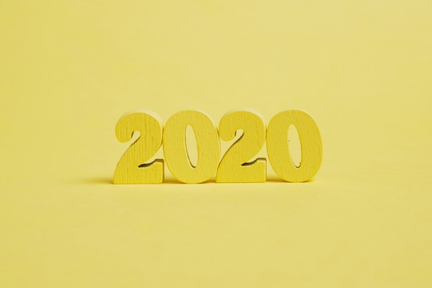 Holzfiguren 2020 auf gelbem Grund.