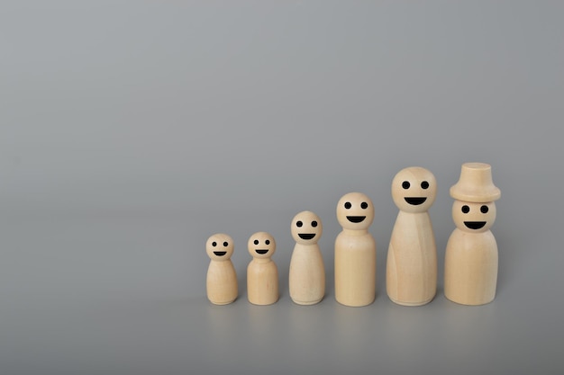Holzfiguren der Familie stehen auf grauem Hintergrund