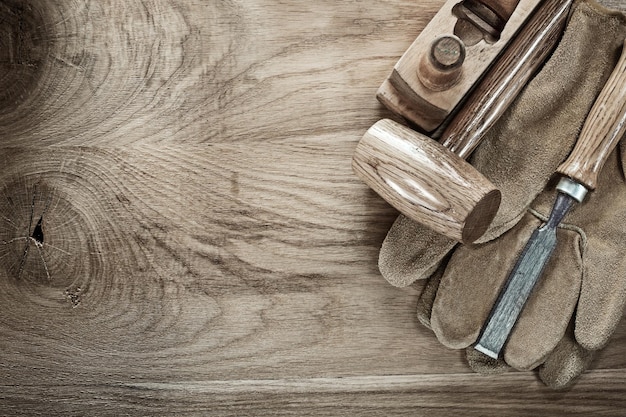 Holzhammer Rasierhobel Meißel Schutzhandschuhe auf Holzplatte