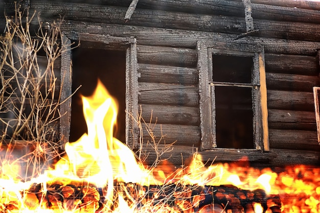 Holzhaus nach dem Brand. Kohlen auf den Protokollen. Die Asche des Hauses vom Feuer. Verbrannte zerstörte Hütte.